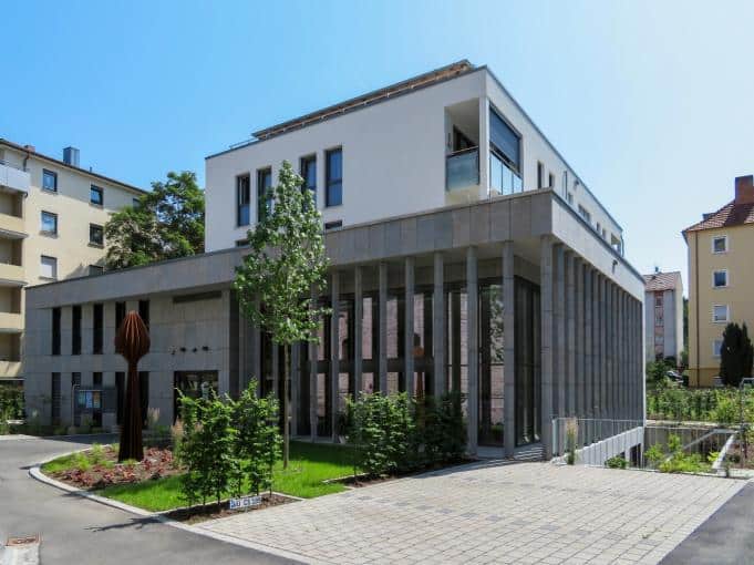 Haus der Kirche in Würzburg, moderner Bau mit Natursteinfassade und hoher Glasfront
